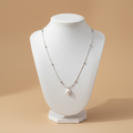 Collar SATÉLITE PERLA cadena plateada con perla barroca colgante en torso beige
